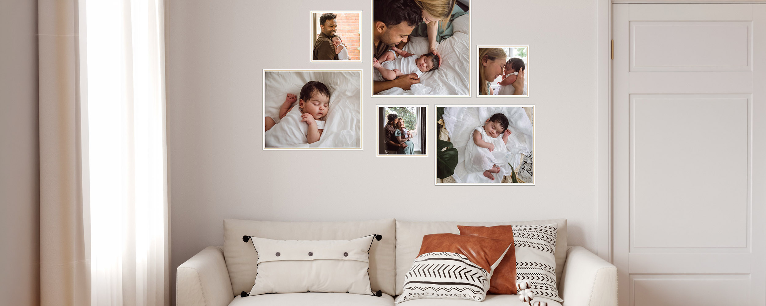 Framed newborn portrait gallery displayed above a sofa in a living room